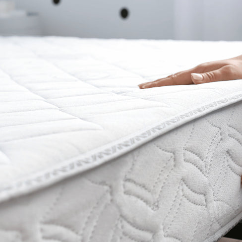 woman placing a memory foam mattress on a bed frame