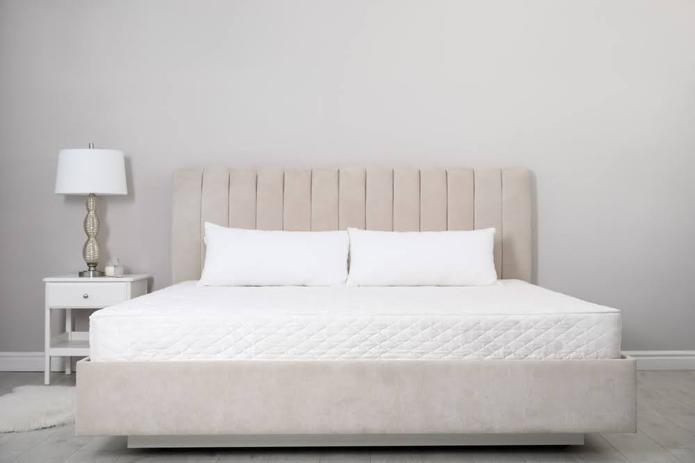 image of a new mattress on a bed frame without sheets or bedding