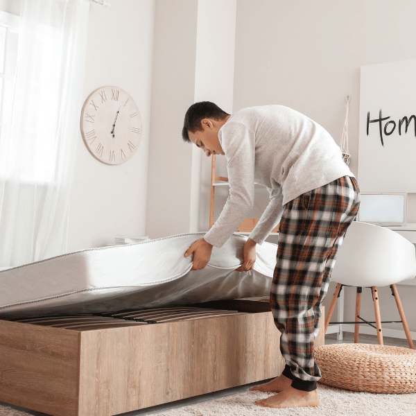 man replacing a mattress on a bed