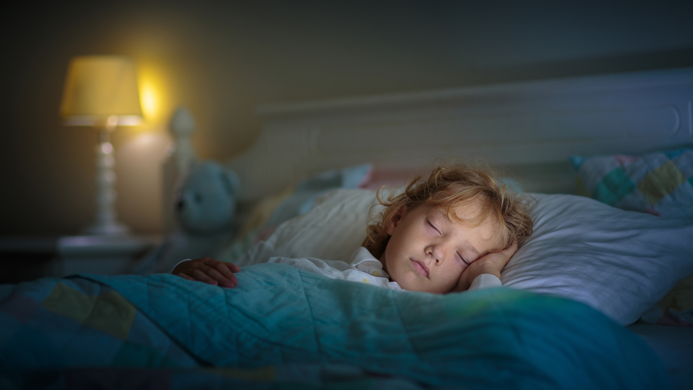 A little girl peacefully sleeping in bed.