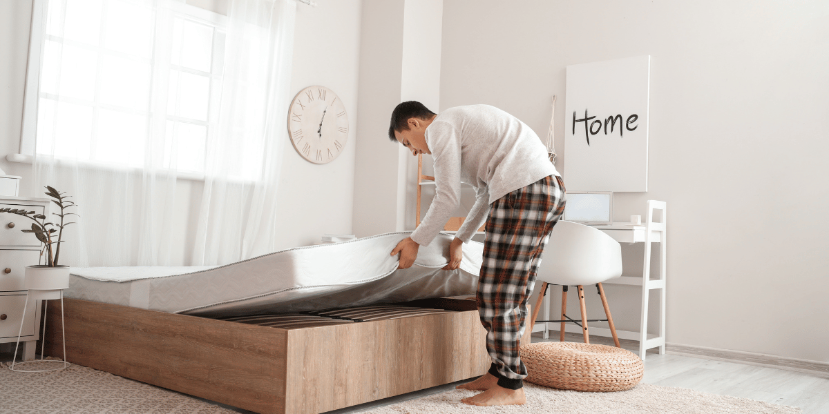 man replacing a mattress on a bed