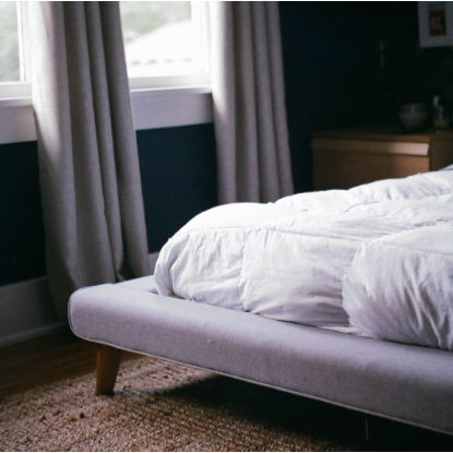staged photo of a mattress in a naturally lit room on a bed frame