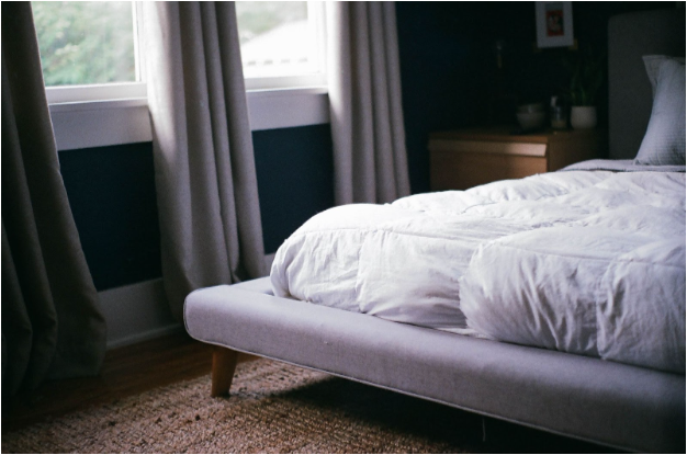 staged photo of a mattress in a naturally lit room on a bed frame