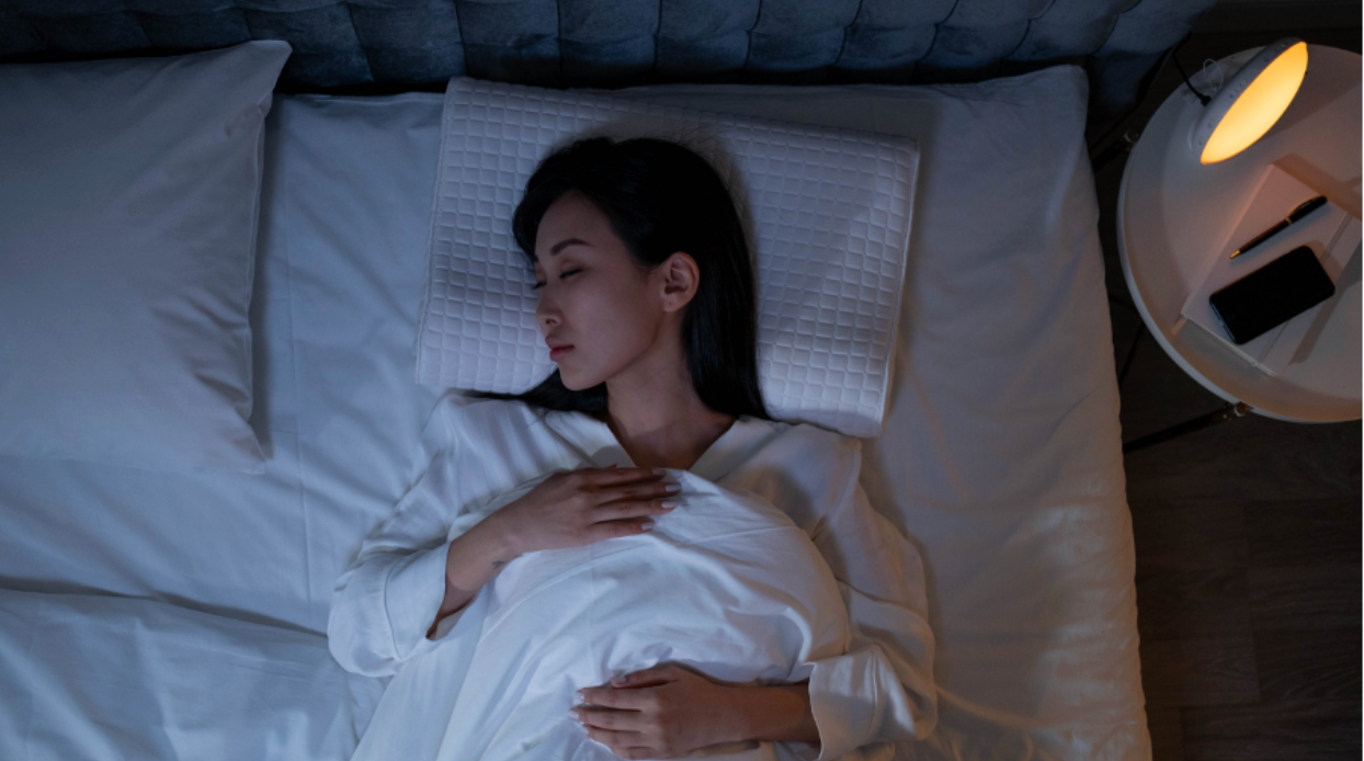 Young woman sleeping peacefully on cool, comfortable mattress