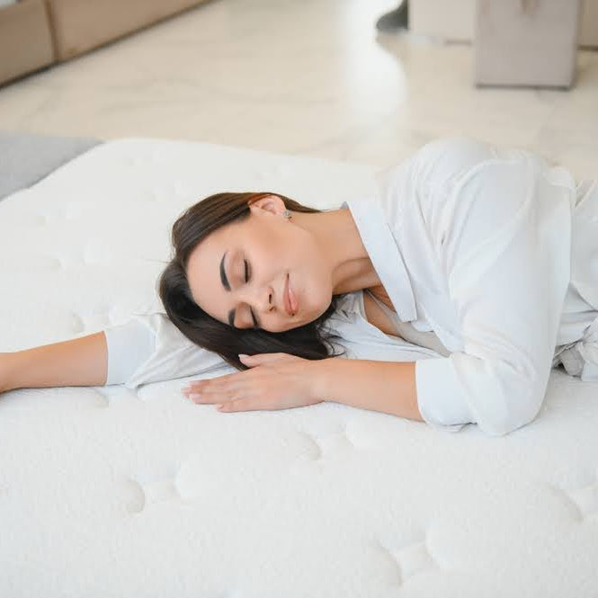 woman lying on a mattress in-store to test its comfort
